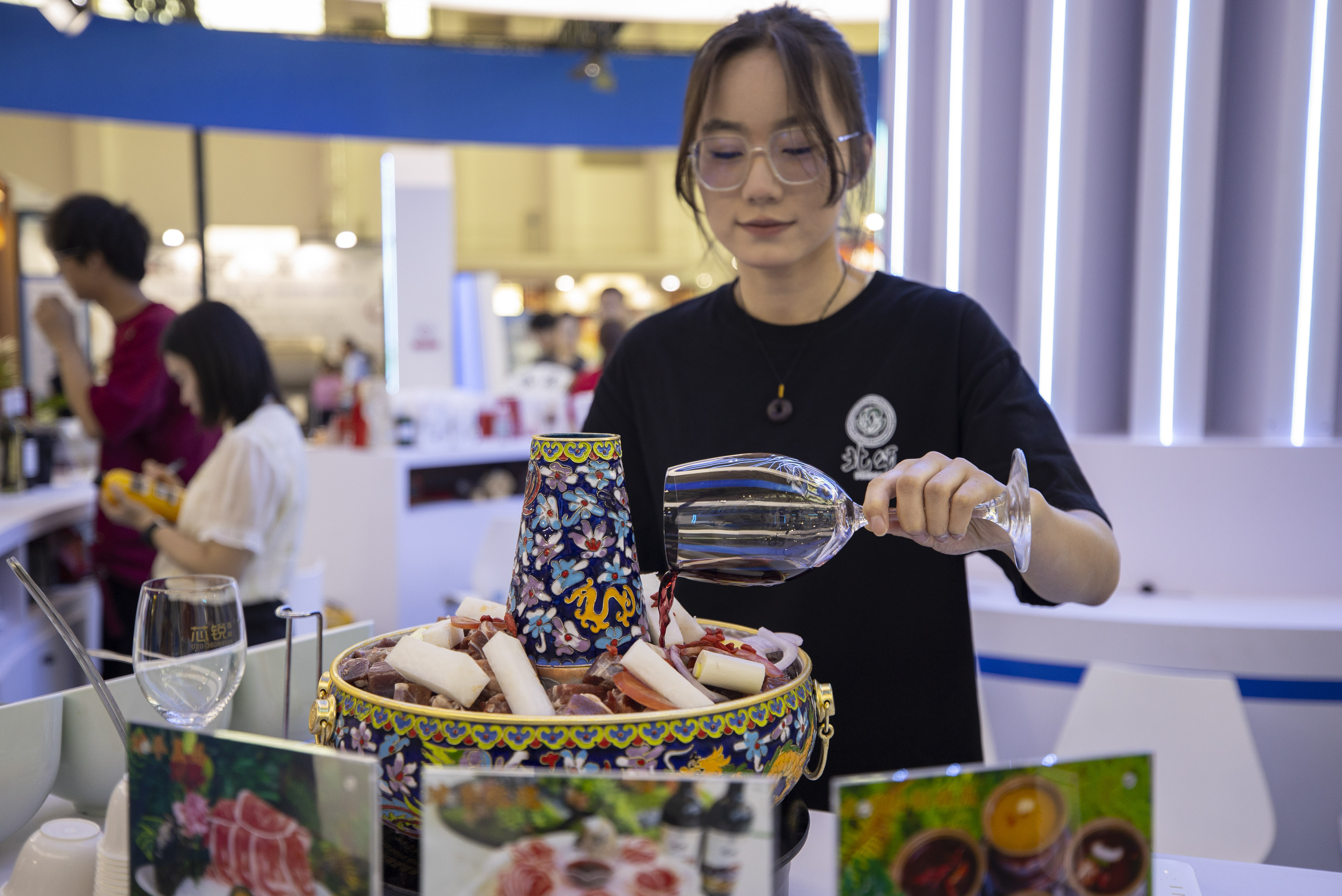 A staff member prepares a serving of tender mutton cooked in red wine-added broth during the Fifth China (Ningxia) International Wine Culture and Tourism Expo in Yinchuan, northwest China's Ningxia Hui Autonomous Region, on June 11, 2025. (Xinhua/Yang Zhisen)