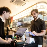 An International Traveler Paying At A Restaurant With Alipay